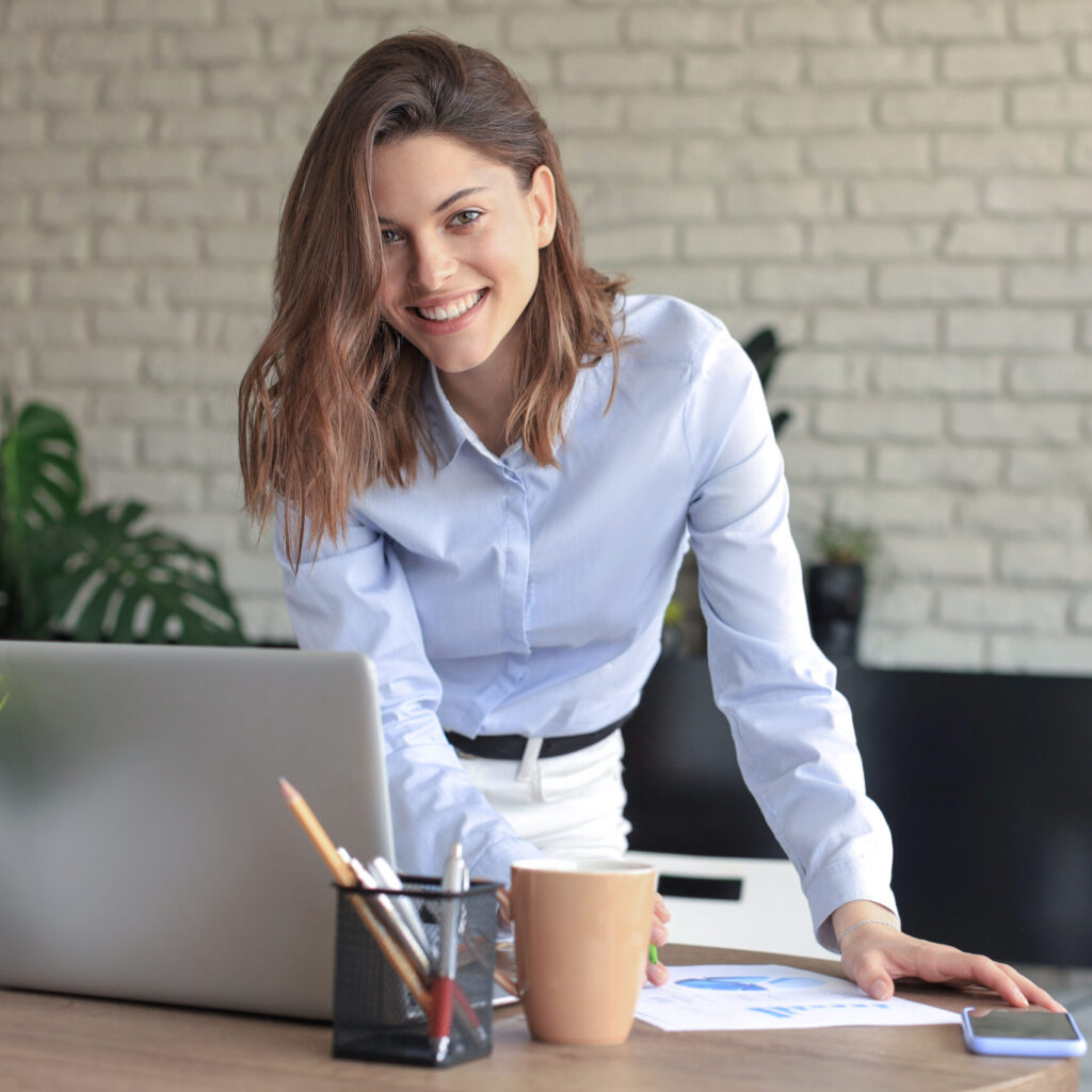 Young business woman standing in her home office writing notes